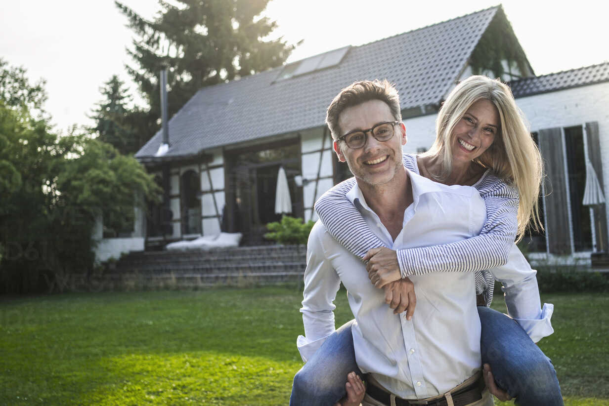 couple standing in front of her house, home, real estate, insurance, future, couple, in balance, family, love, stability, garden, sun, summer, Cologne, NRW, Germany