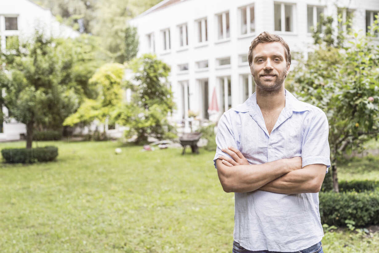 Portrait of mid adult man in front of house