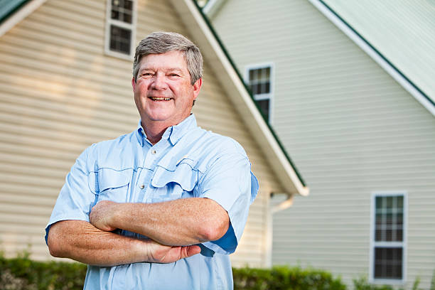 Senior man (60s) standing in back yard.